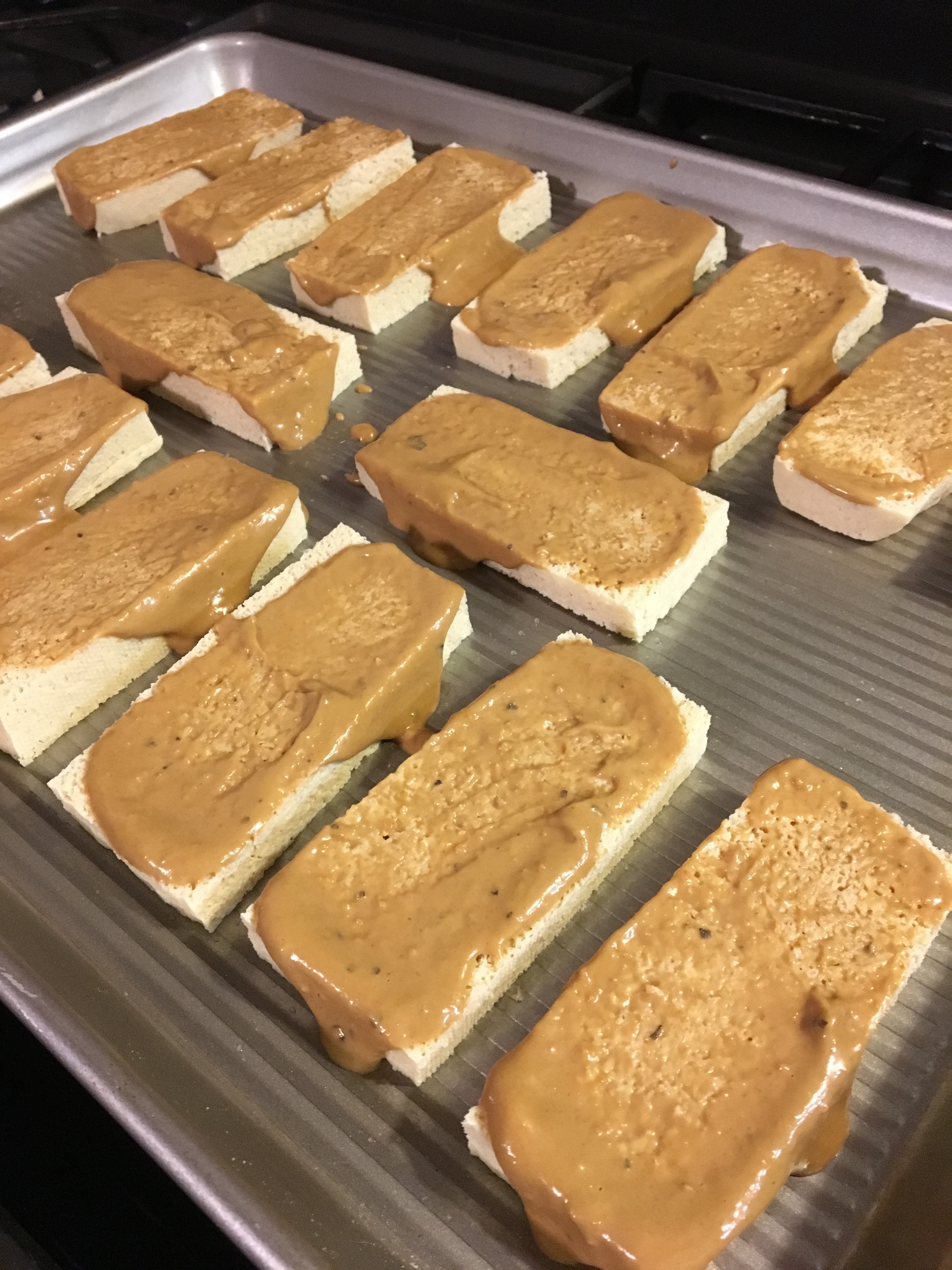 tofu slices on baking tray with peanut sauce