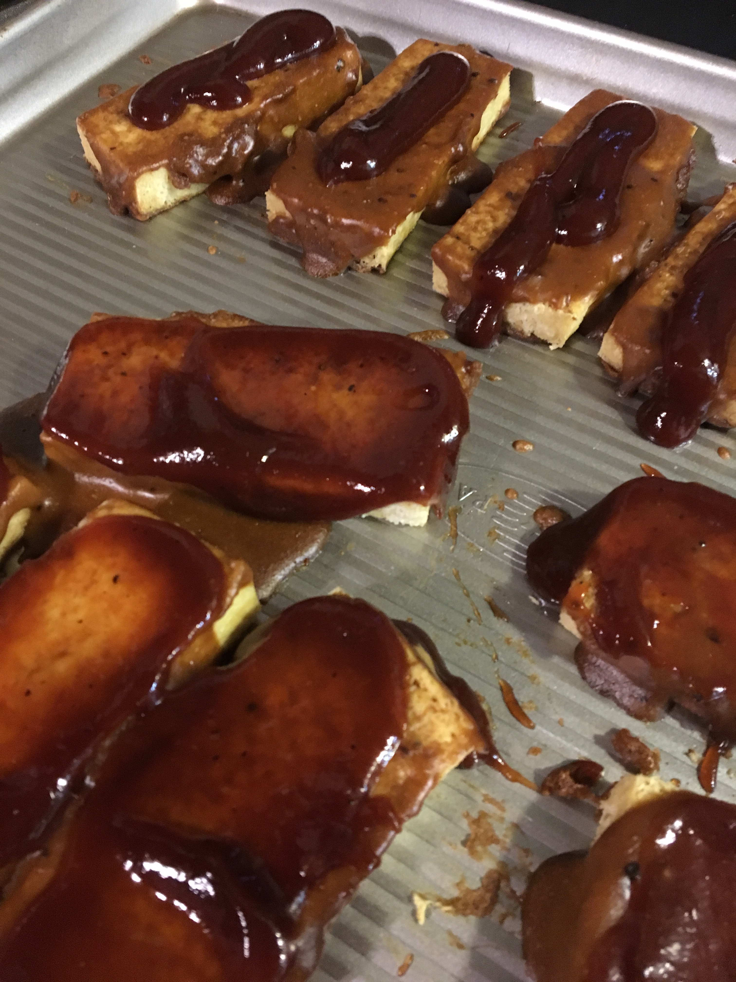 tofu slices on baking pan bbq sauce with barbeque sauce
