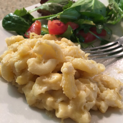 mac and cheese on white plate with salad