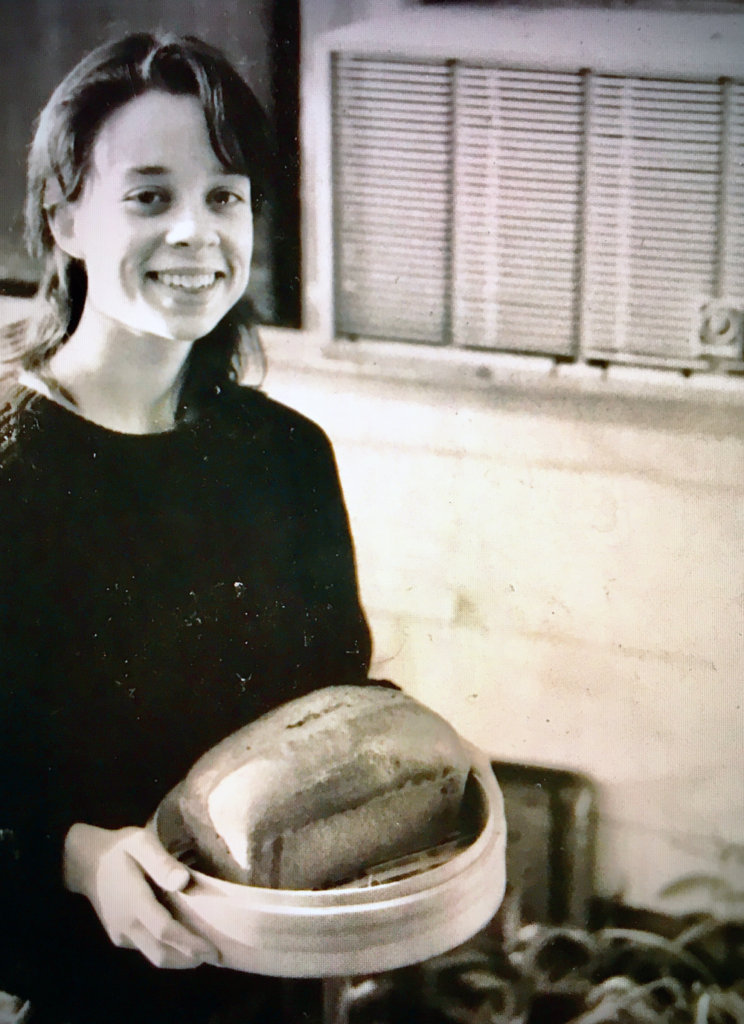 dark haired woman with homemade loaf of bread
